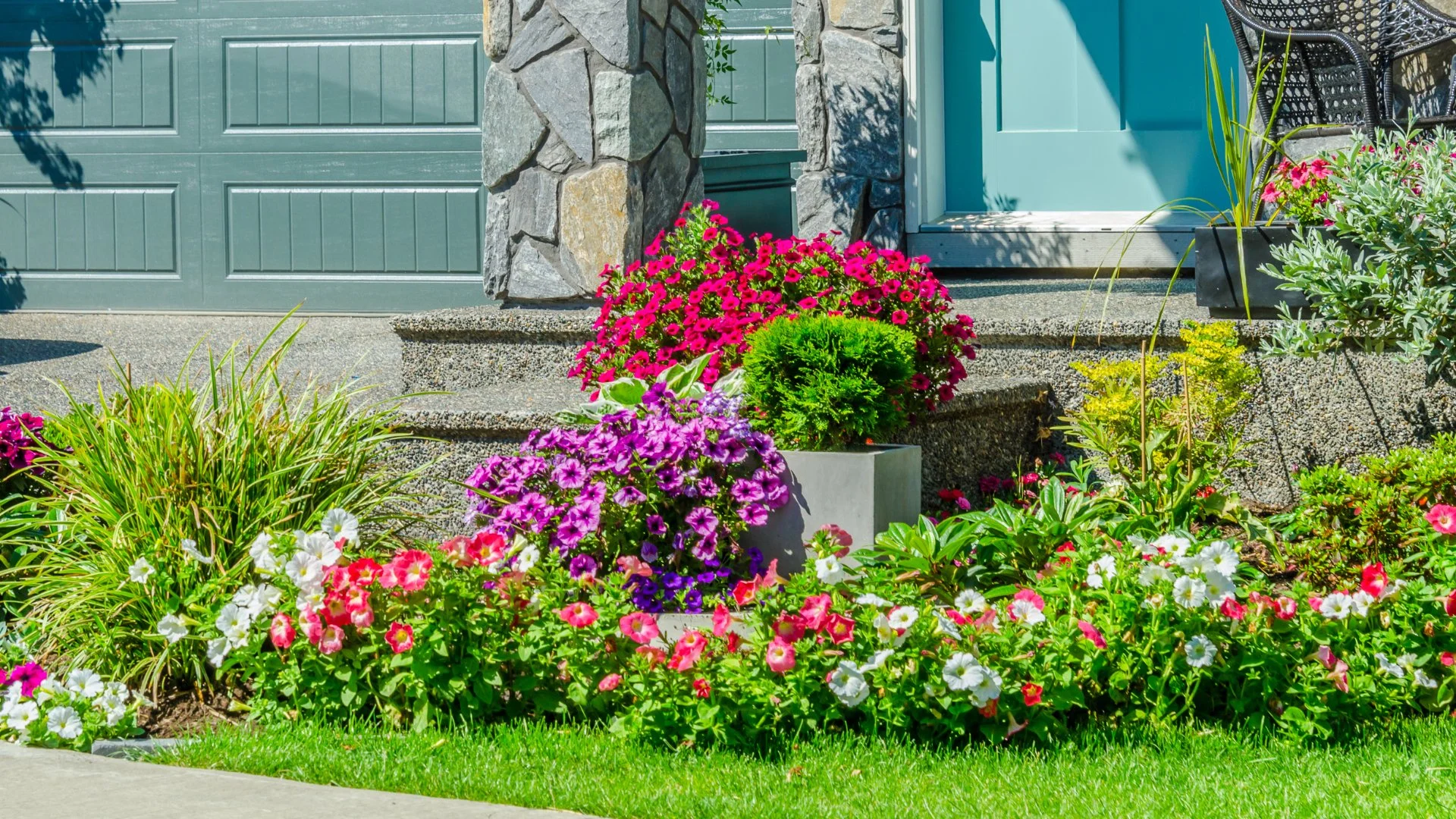 Vibrant garden featuring an array of colorful flowers and decorative planters near a stone entrance