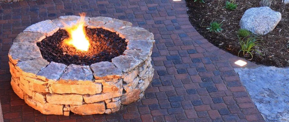 Round fire pit in Tulsa, OK, on a paver patio.