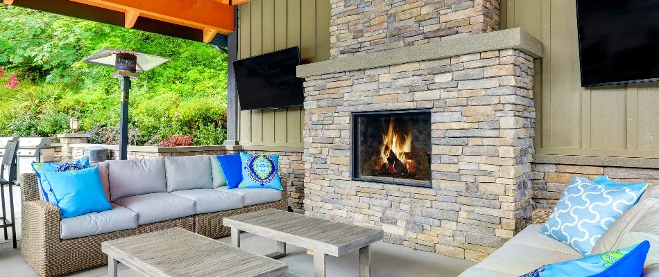 A stone outdoor fireplace in Tulsa, OK, with comfy seating.