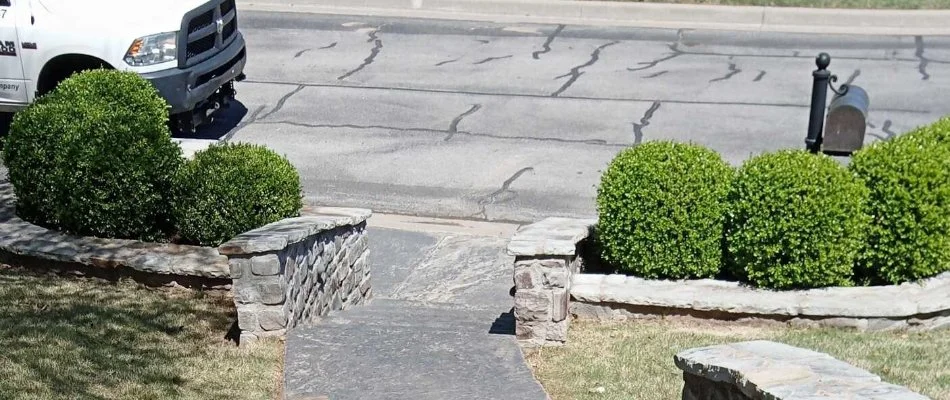 Trimmed shrubs near the sidewalk in Tulsa, OK.