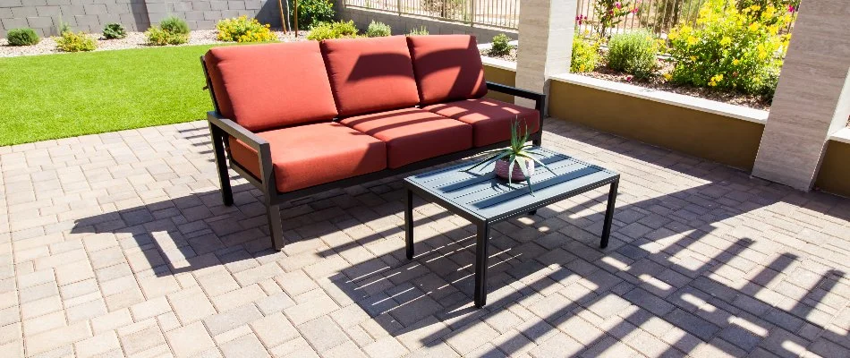 Paver patio in Tulsa, OK, with outdoor furniture by a green lawn.